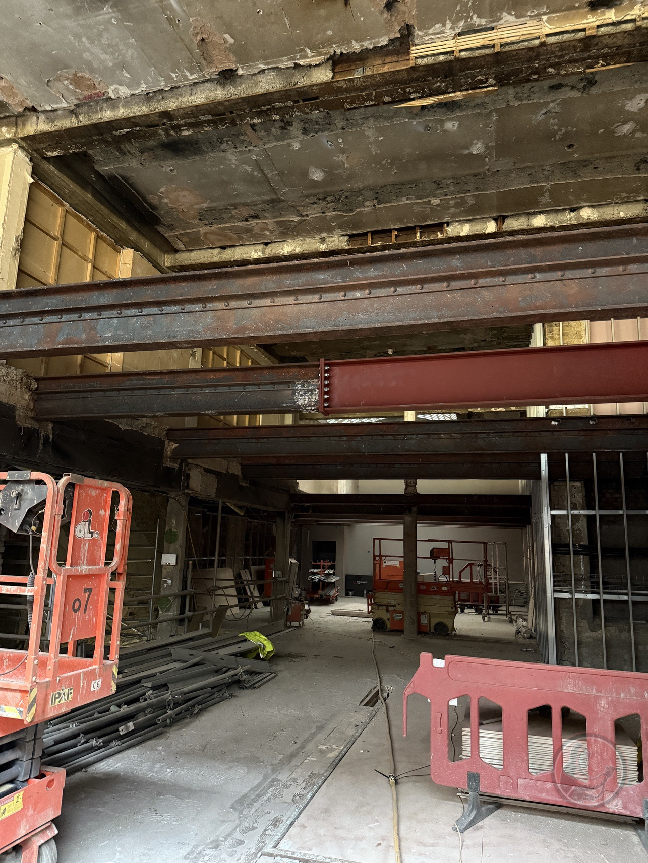 Interior of a construction site with exposed steel beams, scaffolding, and building materials. Ready for blasting
