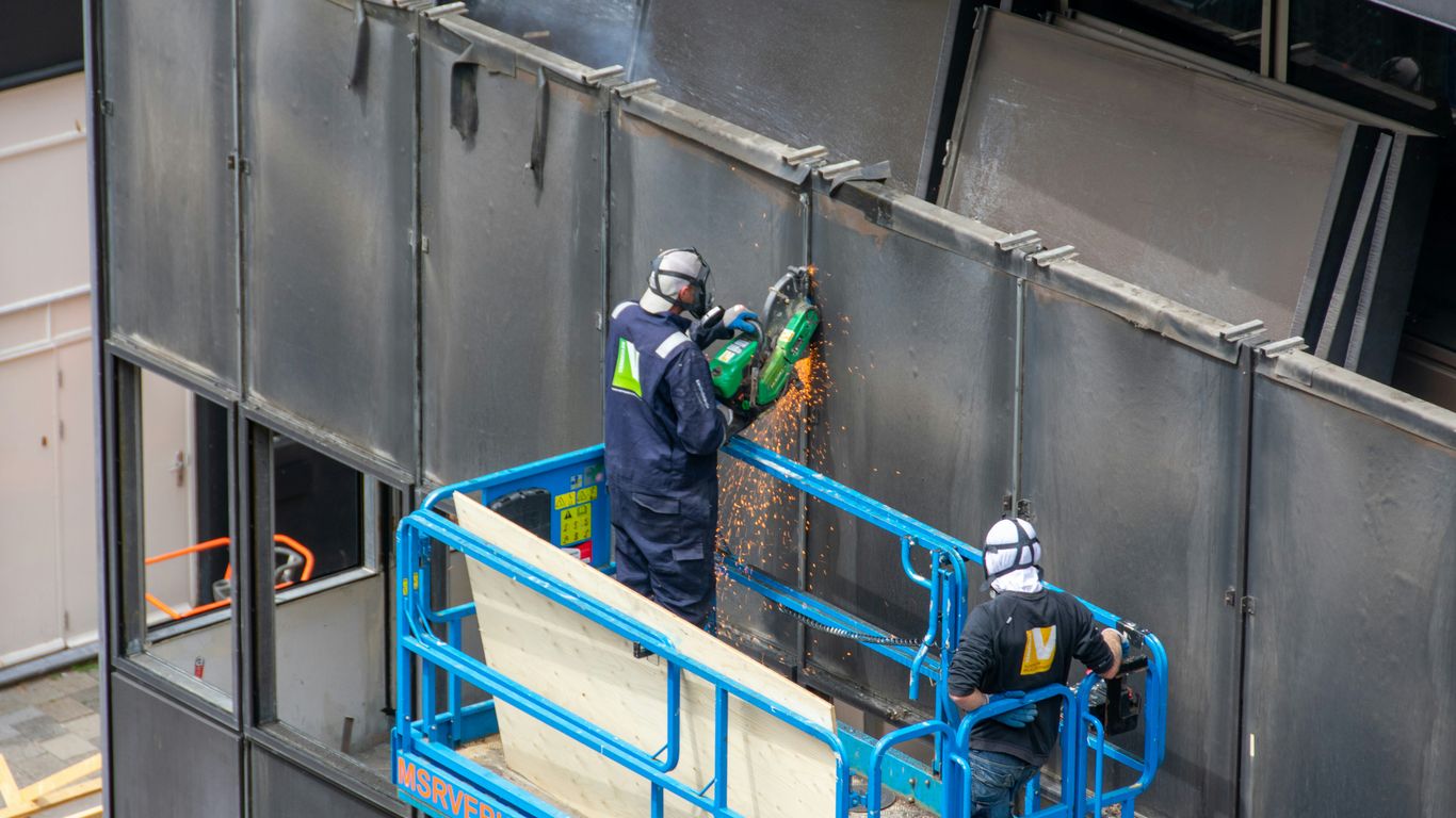 a couple of men standing on top of a metal structure
