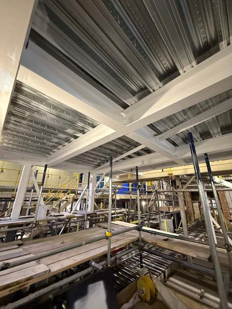 White intumescent-coated beams and columns inside the live manufacturing facility.
