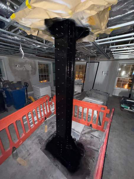 Riveted steel column with a black decorative finish at Devonshire House.