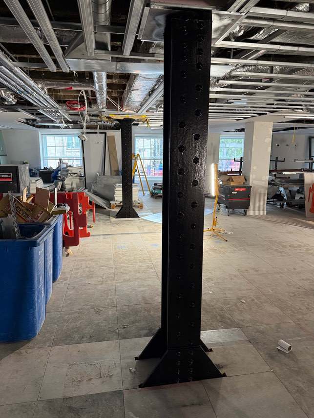Black-finished riveted steel column within the Devonshire House refurbishment.