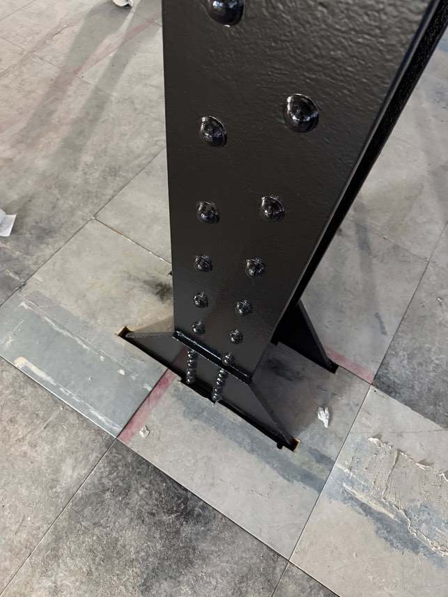 Close-up of the completed black finish on a riveted column base.