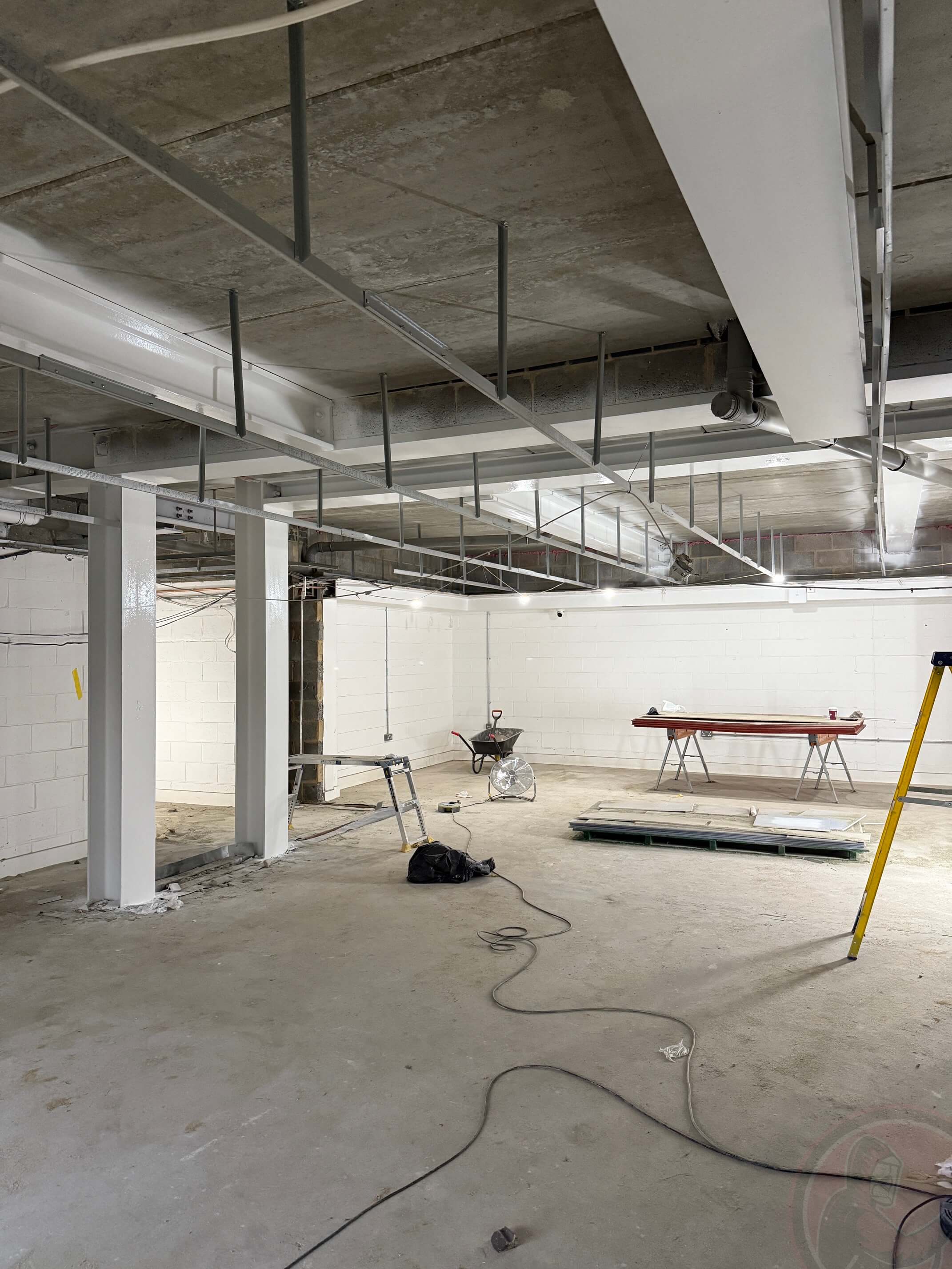 White intumescent-coated steel frame within the community-centre refurbishment.
