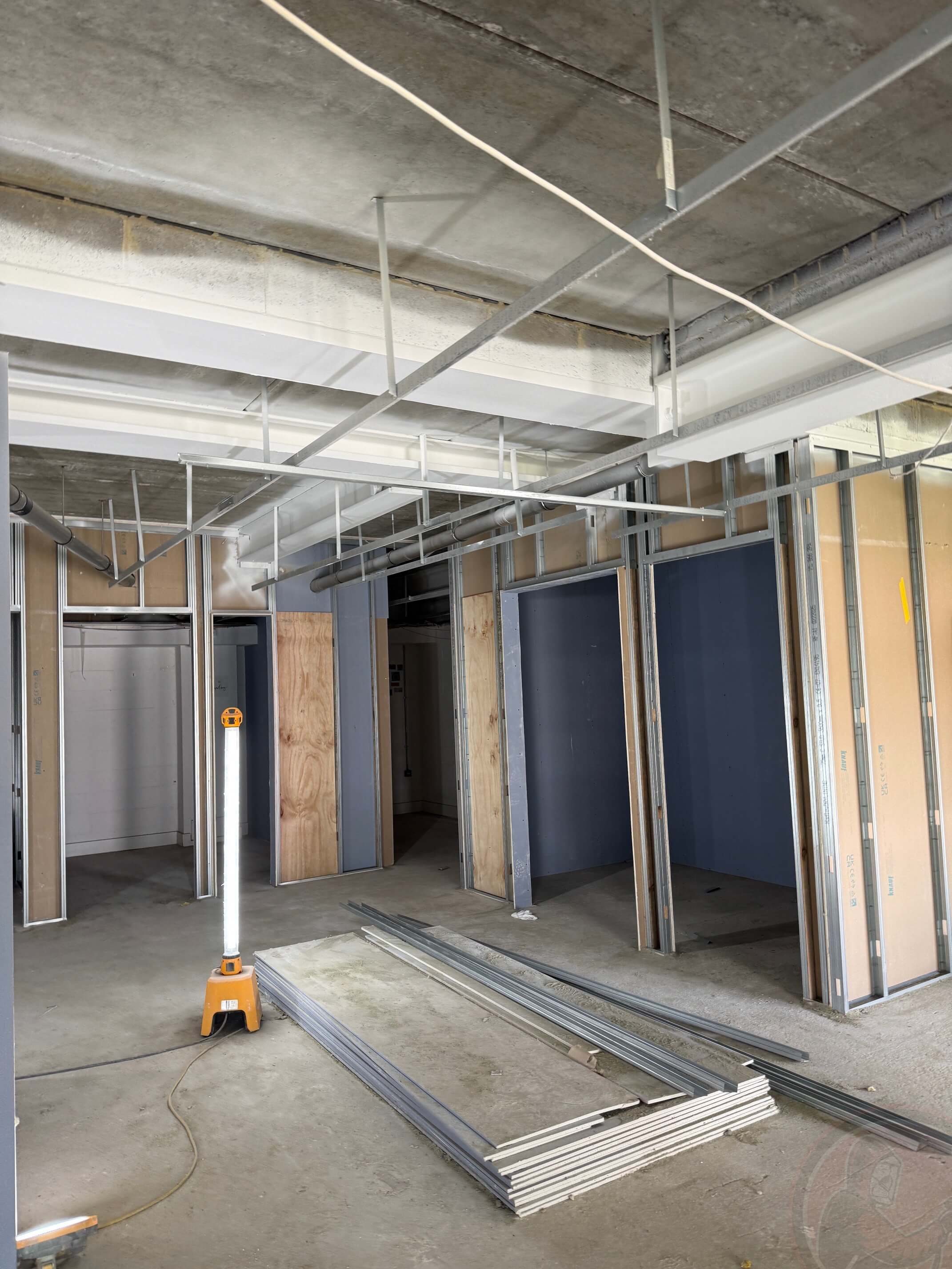 White-coated beams and columns beside new internal partition framing.