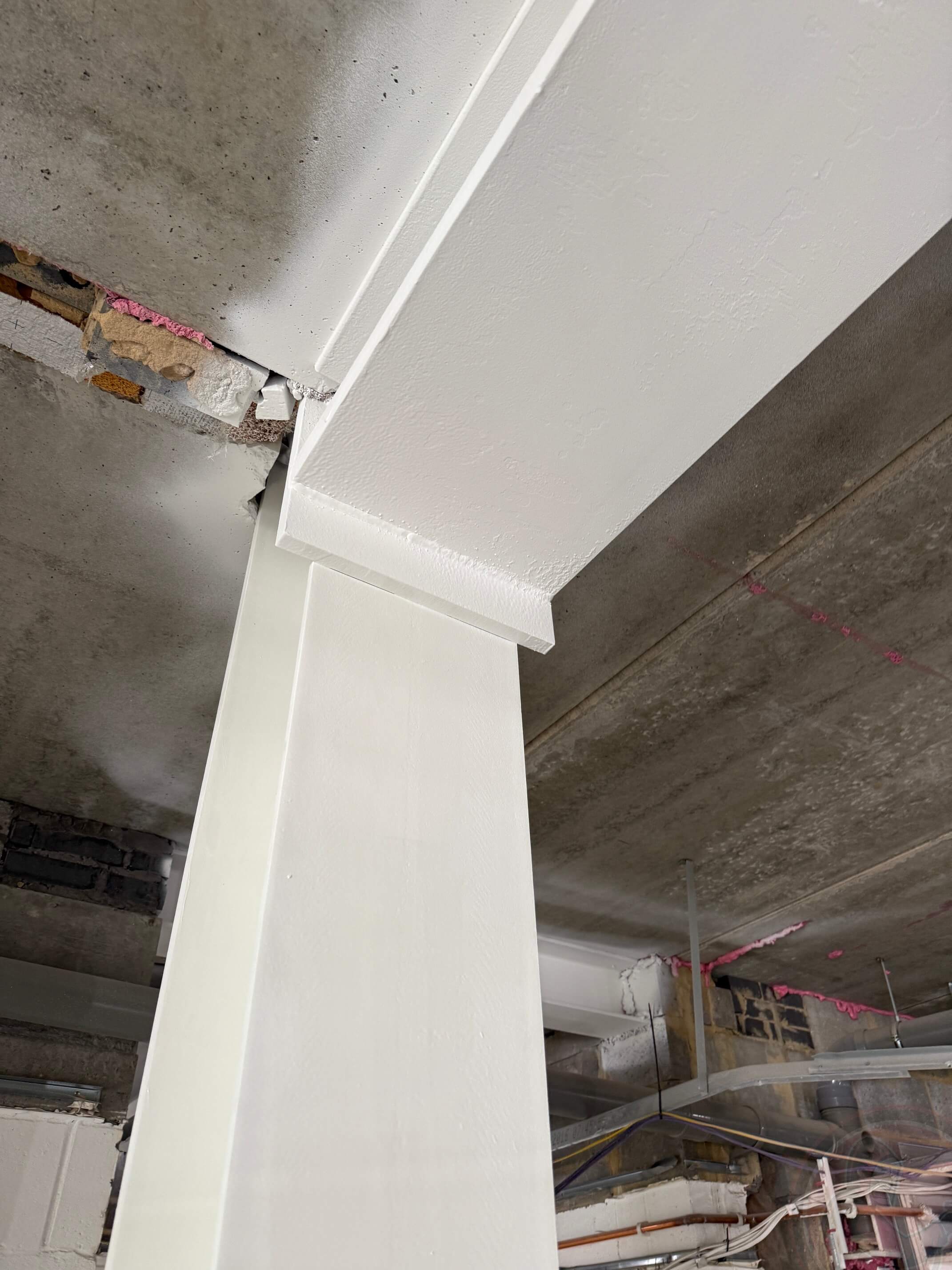 Completed white coating at a structural column-to-beam connection.