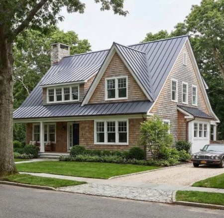 Modern roof with angular wooden panels and metal edges against a cloudy sky.