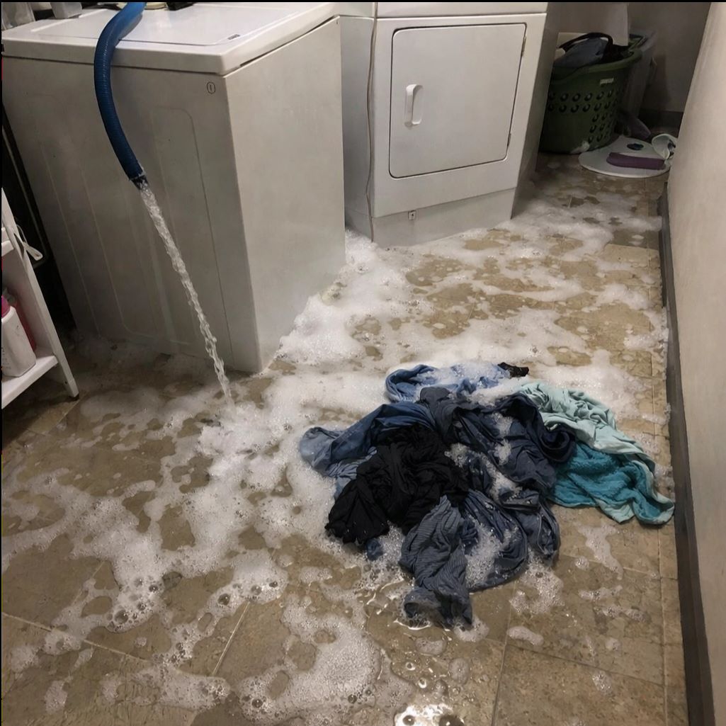 Interior of a severely fire-damaged kitchen with burnt cabinets, exposed wall studs, scattered debris, and smoke stains.