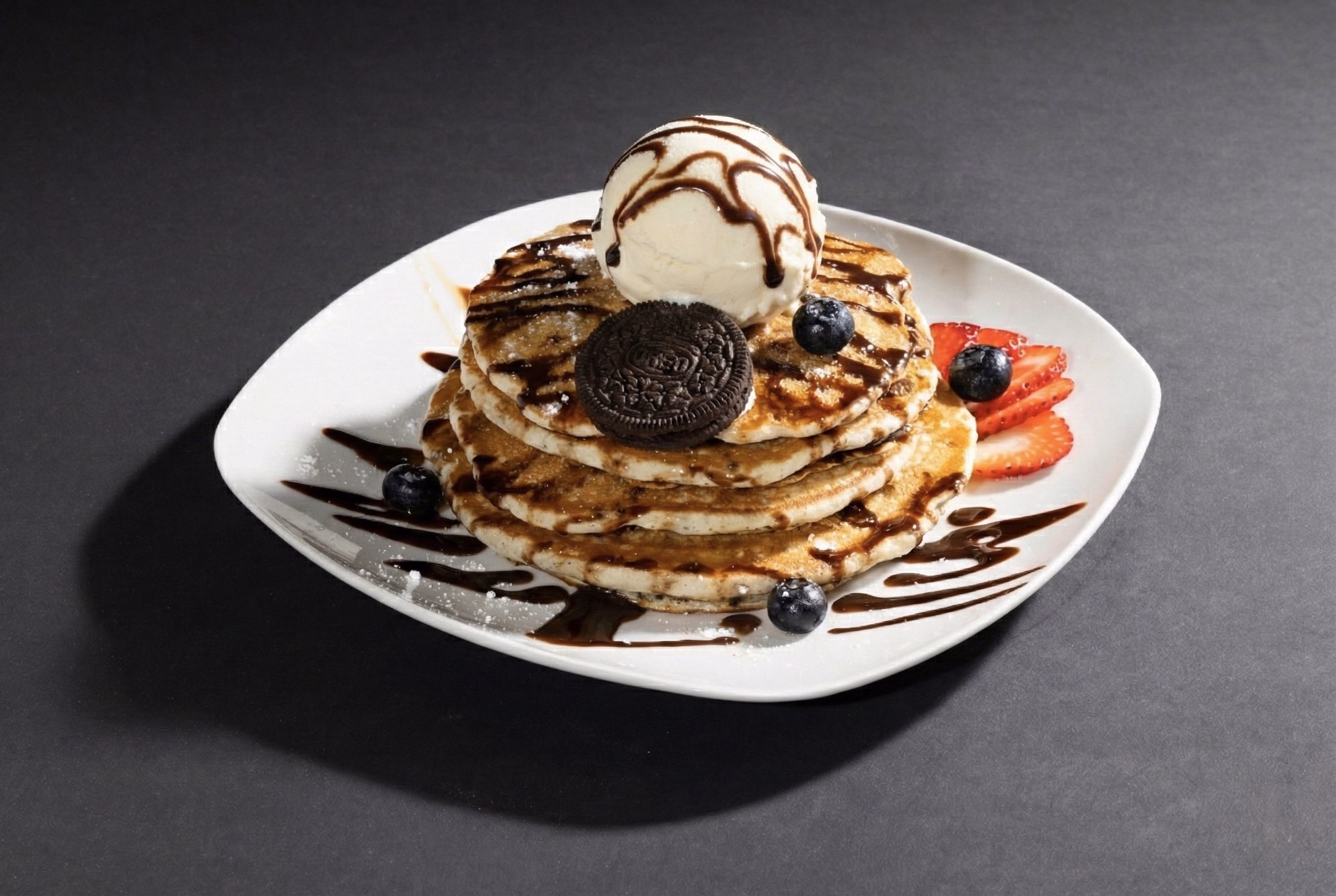 Neon sign with pink and blue glowing text saying 'COMING SOON' on a dark brick wall background.