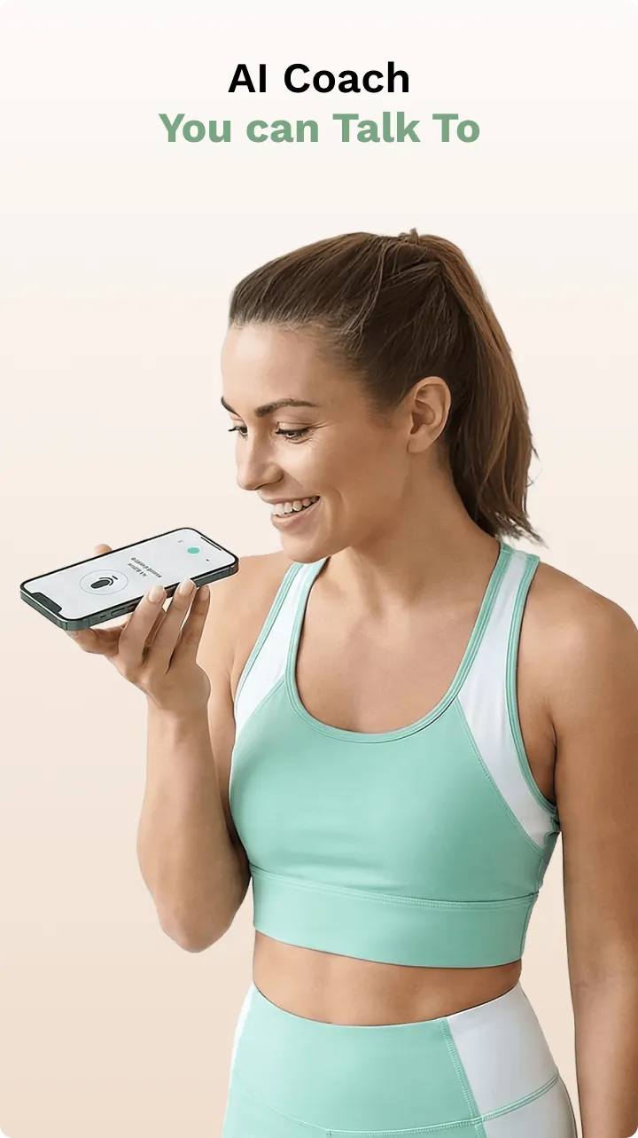 Smiling woman in green workout outfit holding a smartphone near her mouth with AI Coach app open.