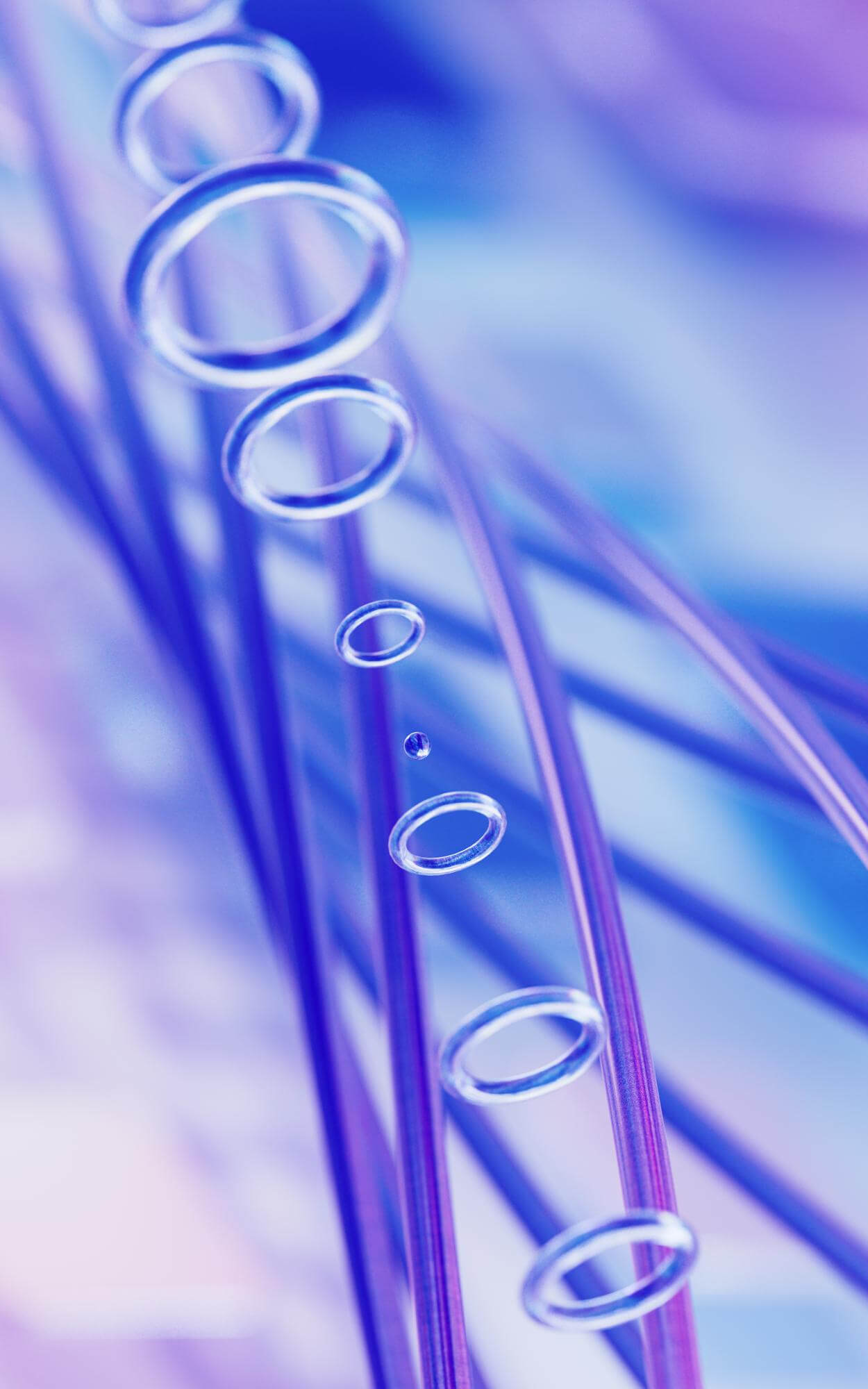 Nærbilde av flere gjennomsiktige luftbobler som svever blant blå og lilla linjer i en abstrakt, fargerik bakgrunn.