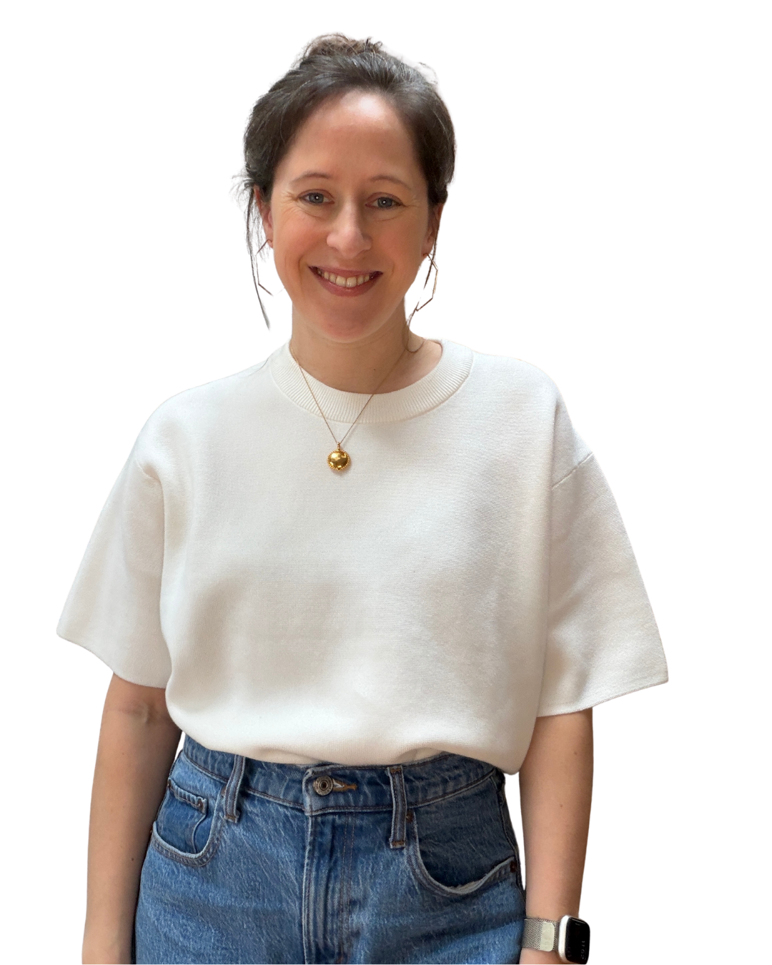 Smiling woman wearing a white short-sleeve sweater, blue jeans, gold pendant necklace, and smartwatch.