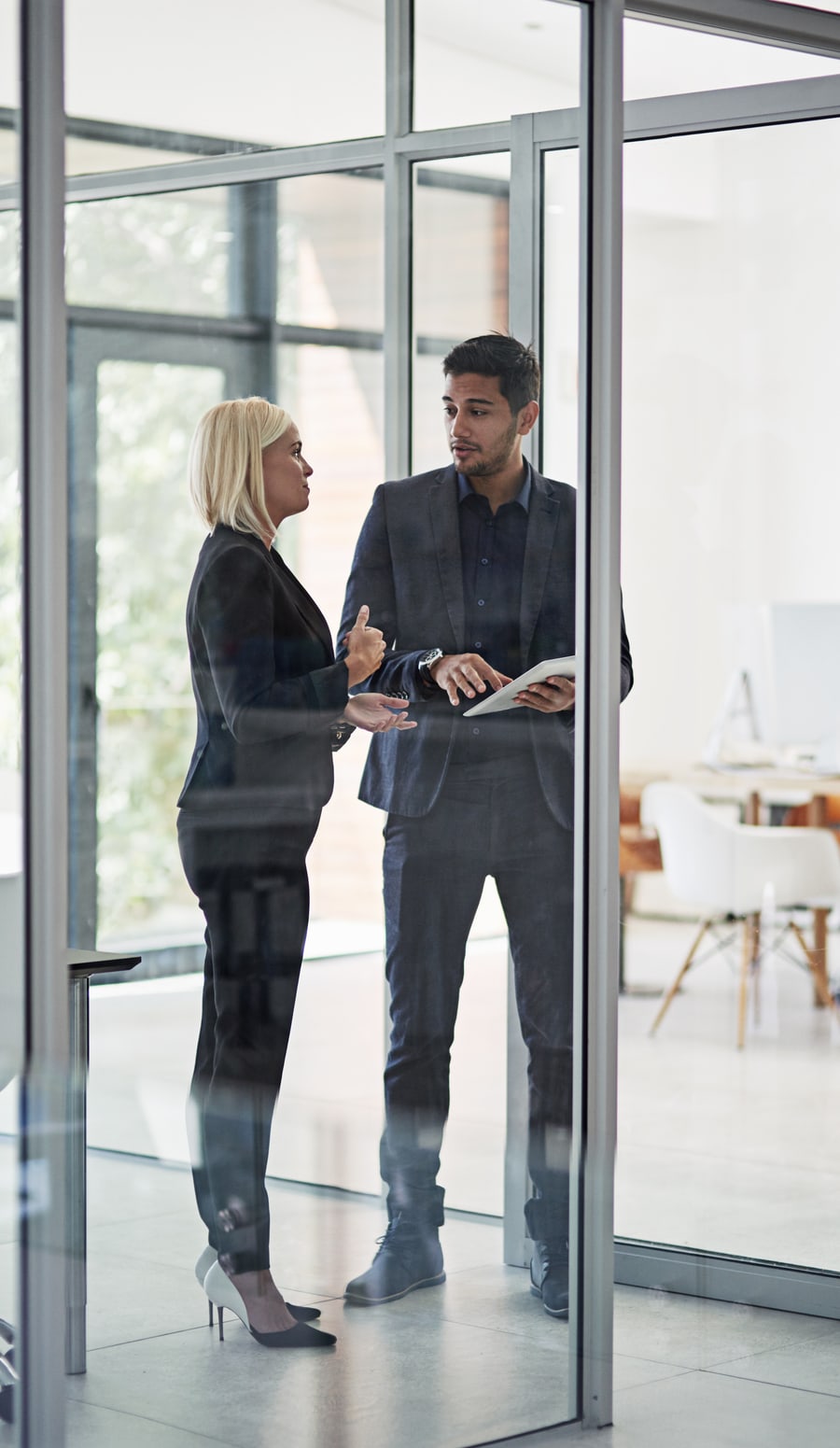 Two executives talking a decision through in a glass walled office