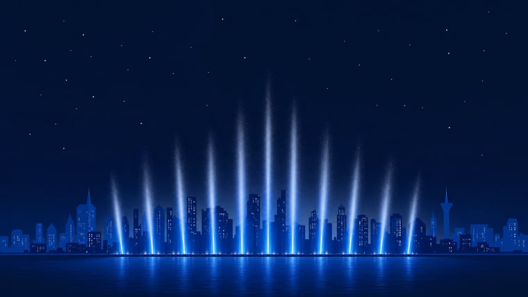 Fountain plumes lit against a city skyline