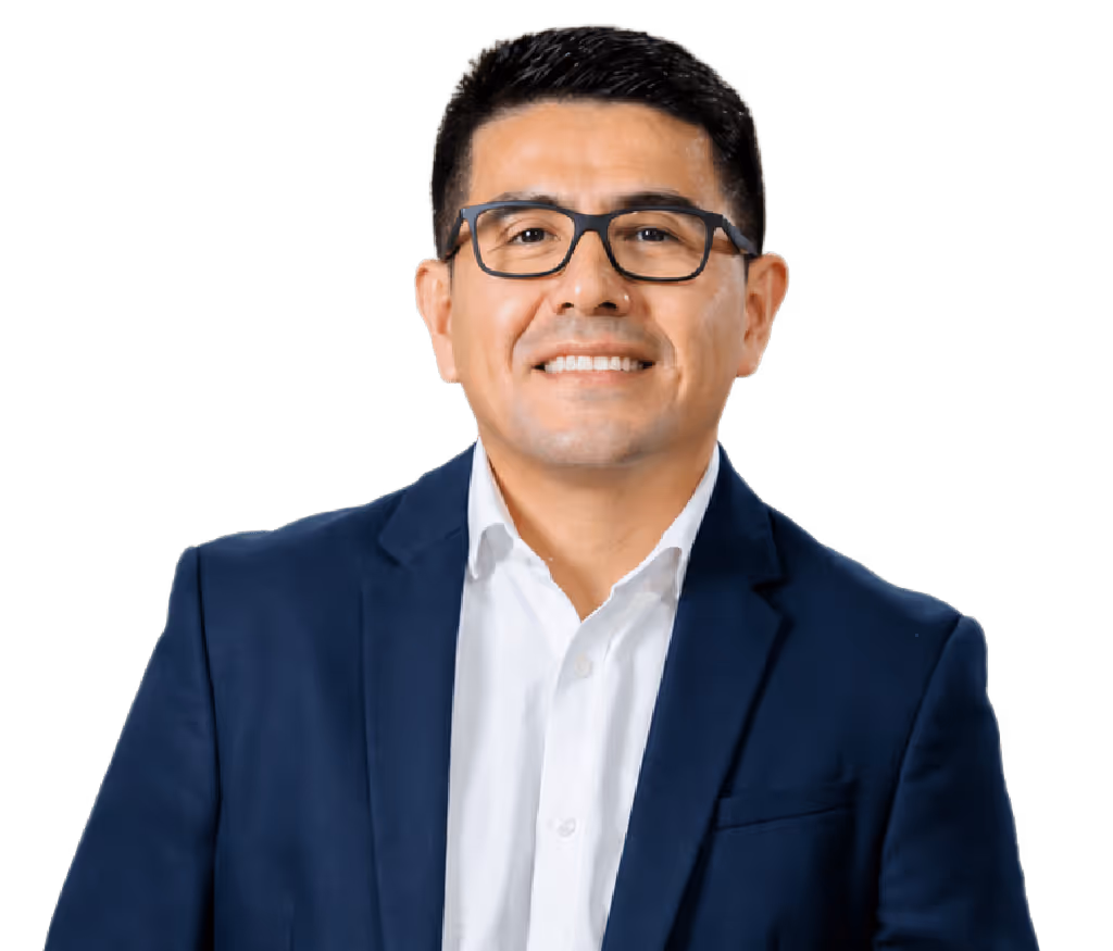 Hombre calvo con gafas redondas oscuras, camisa beige y collar de perlas sonriente.