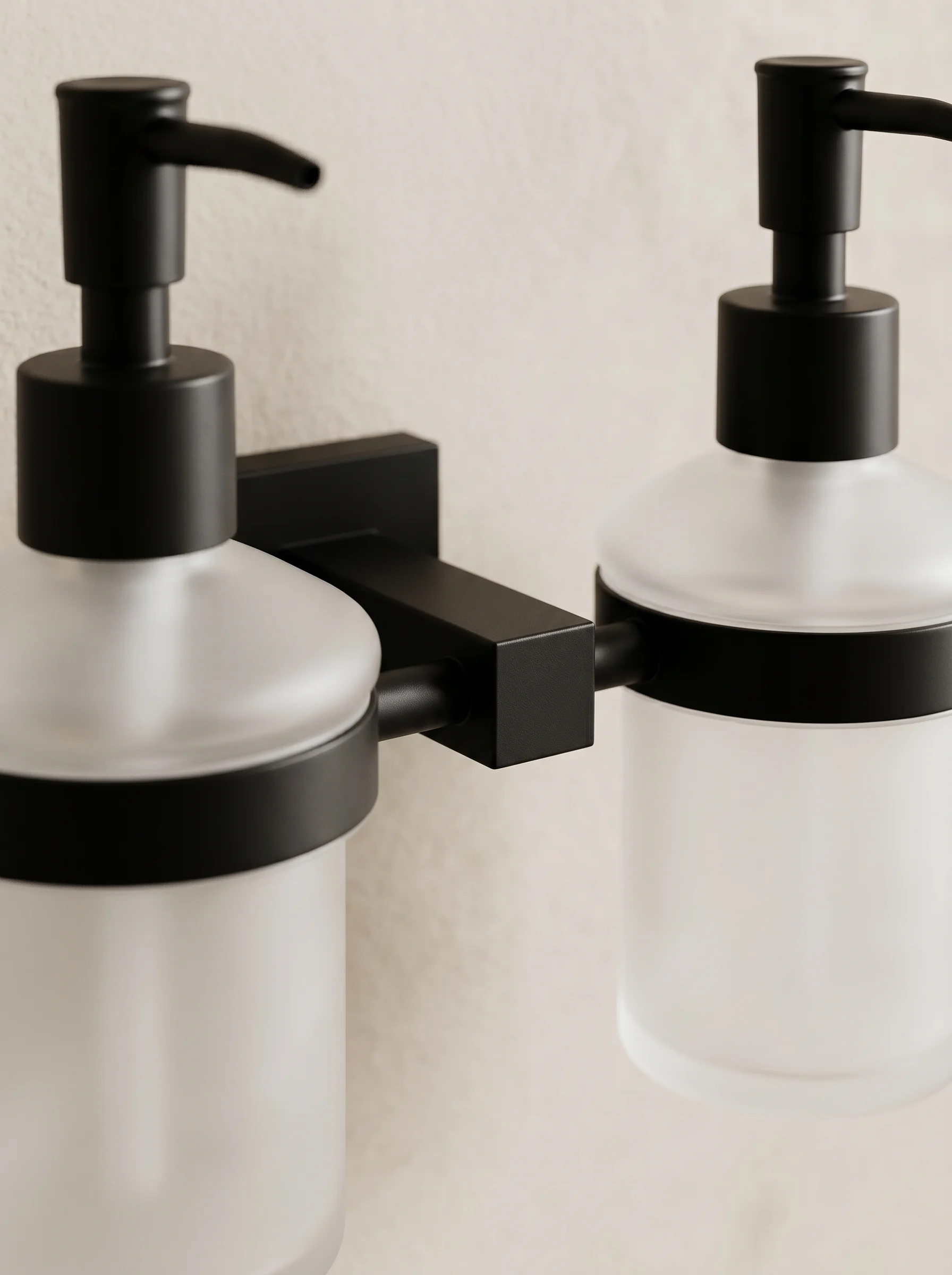 Duo double soap dispenser detail — two frosted glass vessels on a matte black mount
