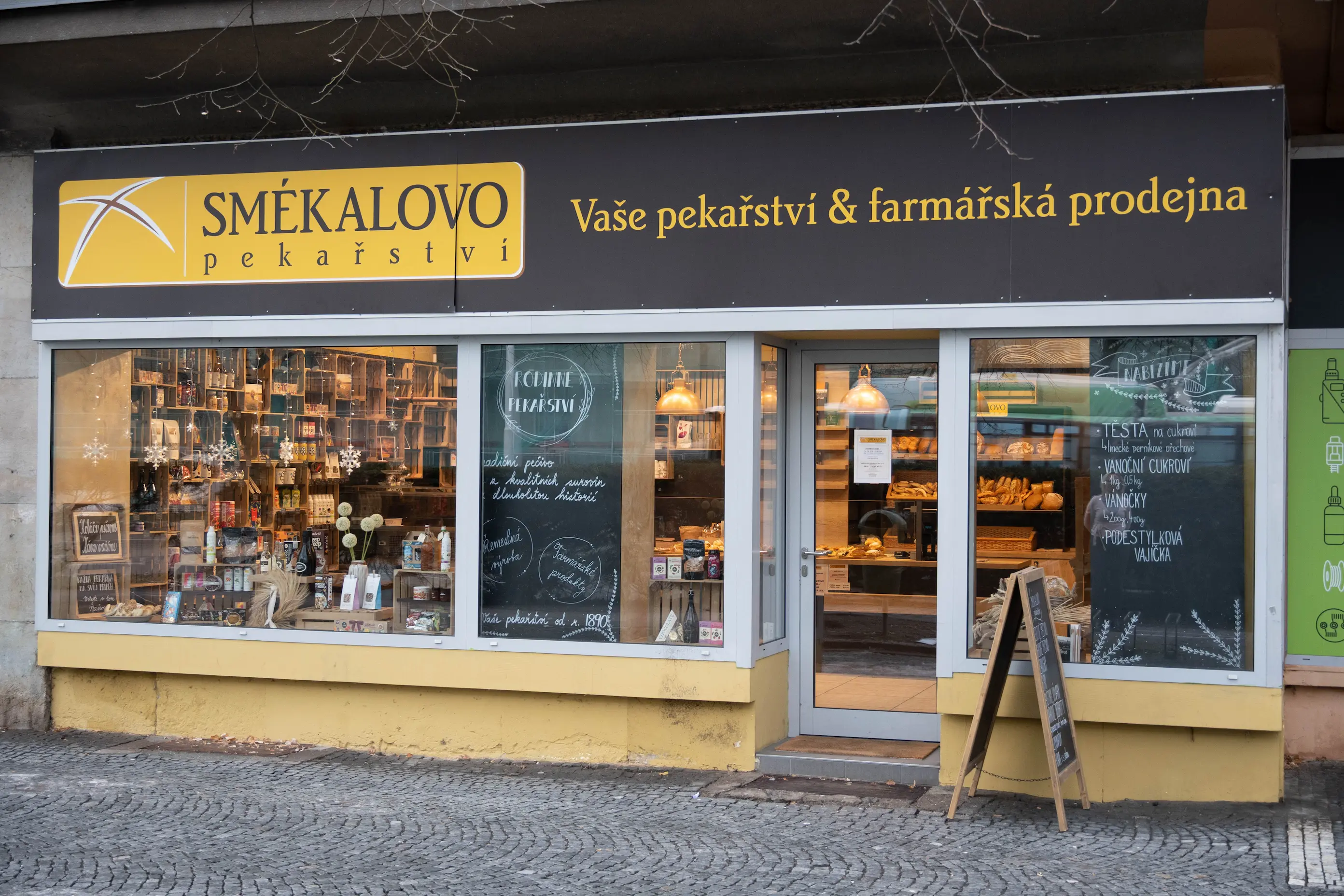 Výloha a vstup do pekařství Smékalovo s nabídkou pečiva a farmářských produktů, s nápisem Vaše pekařství & farmářská prodejna.