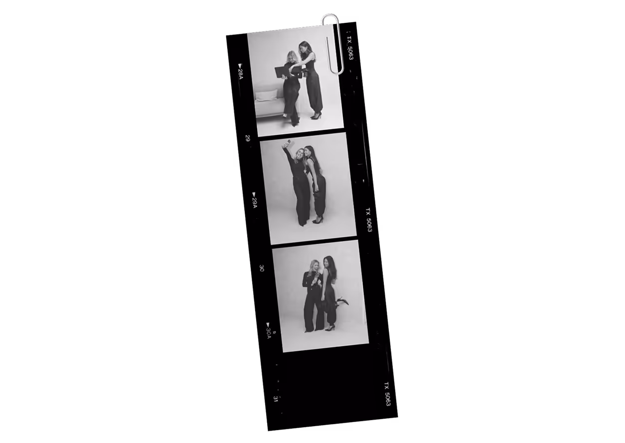 Black and white film strip with three portraits of two women dressed in black, posing and interacting in a studio.