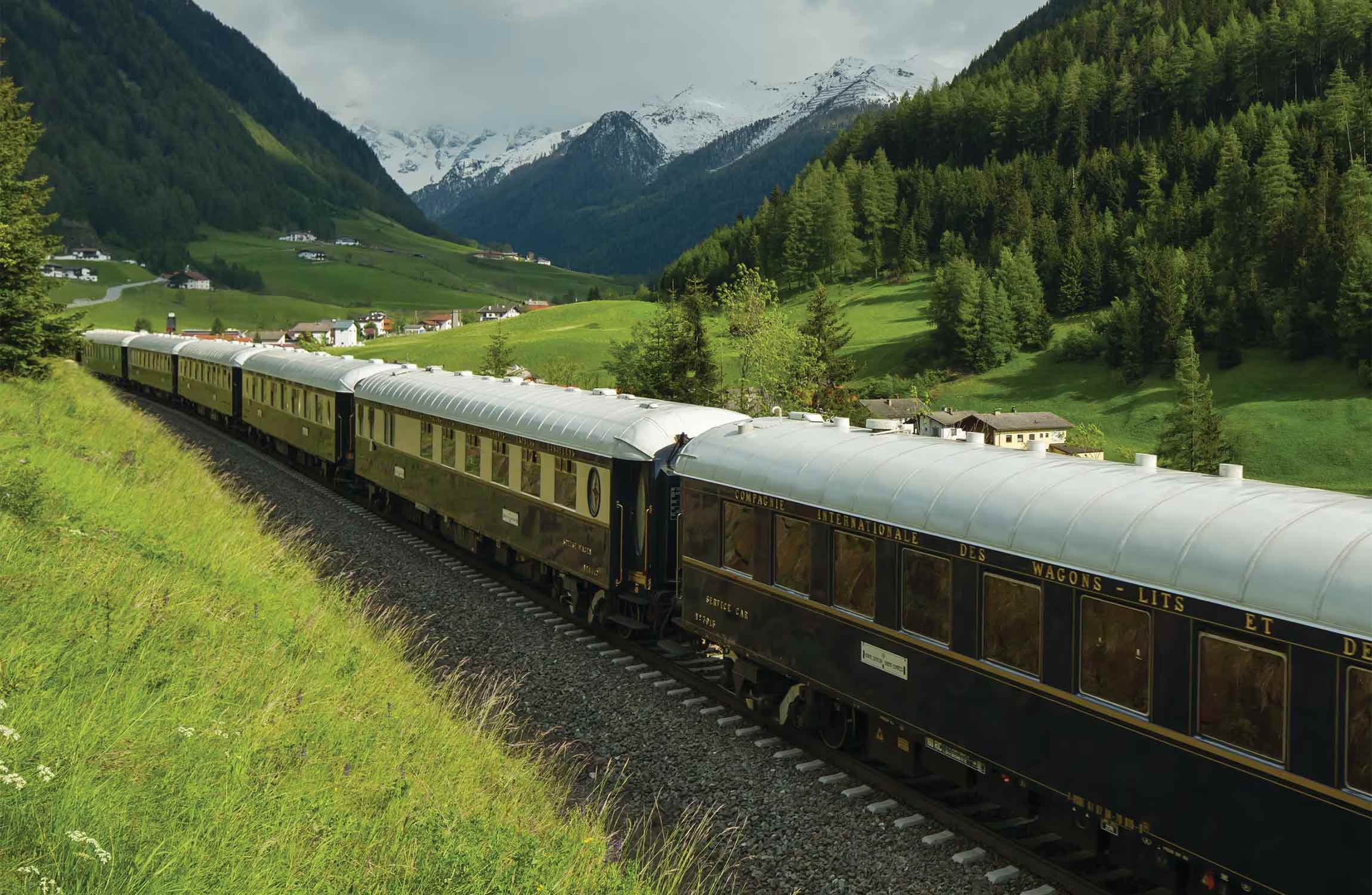 Exterior of the Venice Simplon-Orient-Express luxury train operated by Belmond traveling through scenic European landscapes