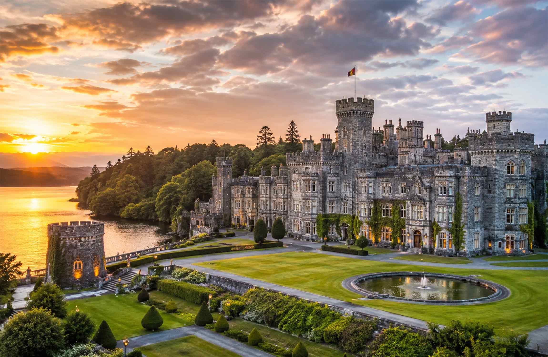 Ashford Castle at sunset, one of Europe's most luxurious castle hotels surrounded by gardens and a lake.
