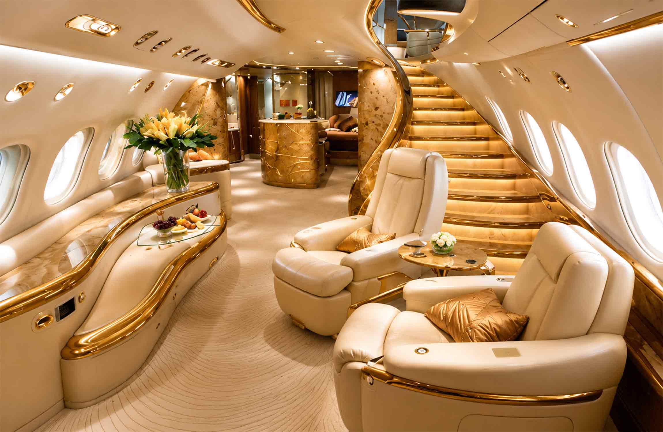 Ultra-luxurious VIP lounge inside the Airbus A380 Flying Palace featuring illuminated grand staircase, cream leather seating, marble finishes, and bespoke private jet interior design.