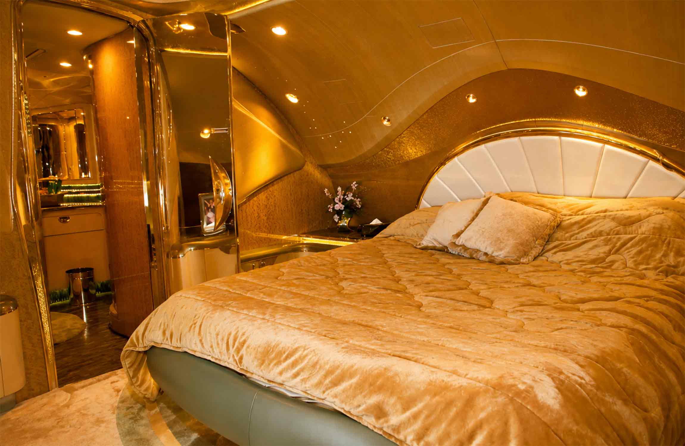 Master bedroom suite inside the Airbus A380 Flying Palace featuring a king-size bed, gold-accented finishes, bespoke luxury furnishings, and an ultra-exclusive private jet interior.
