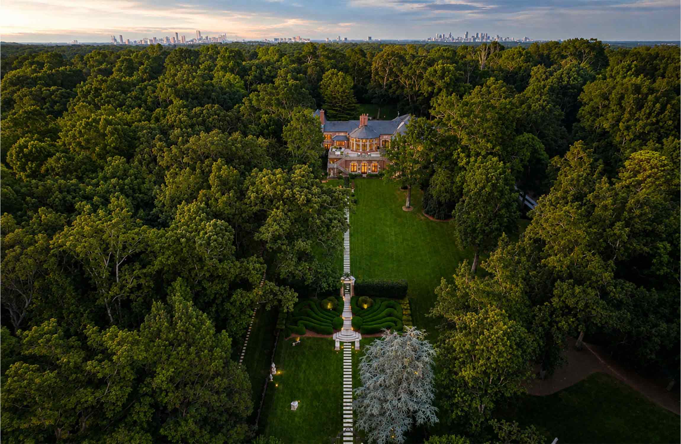 Aerial view of Chestnut Hall, Atlanta's iconic English Tudor estate, showcasing its 18-acre private grounds, formal gardens and surrounding woodland.