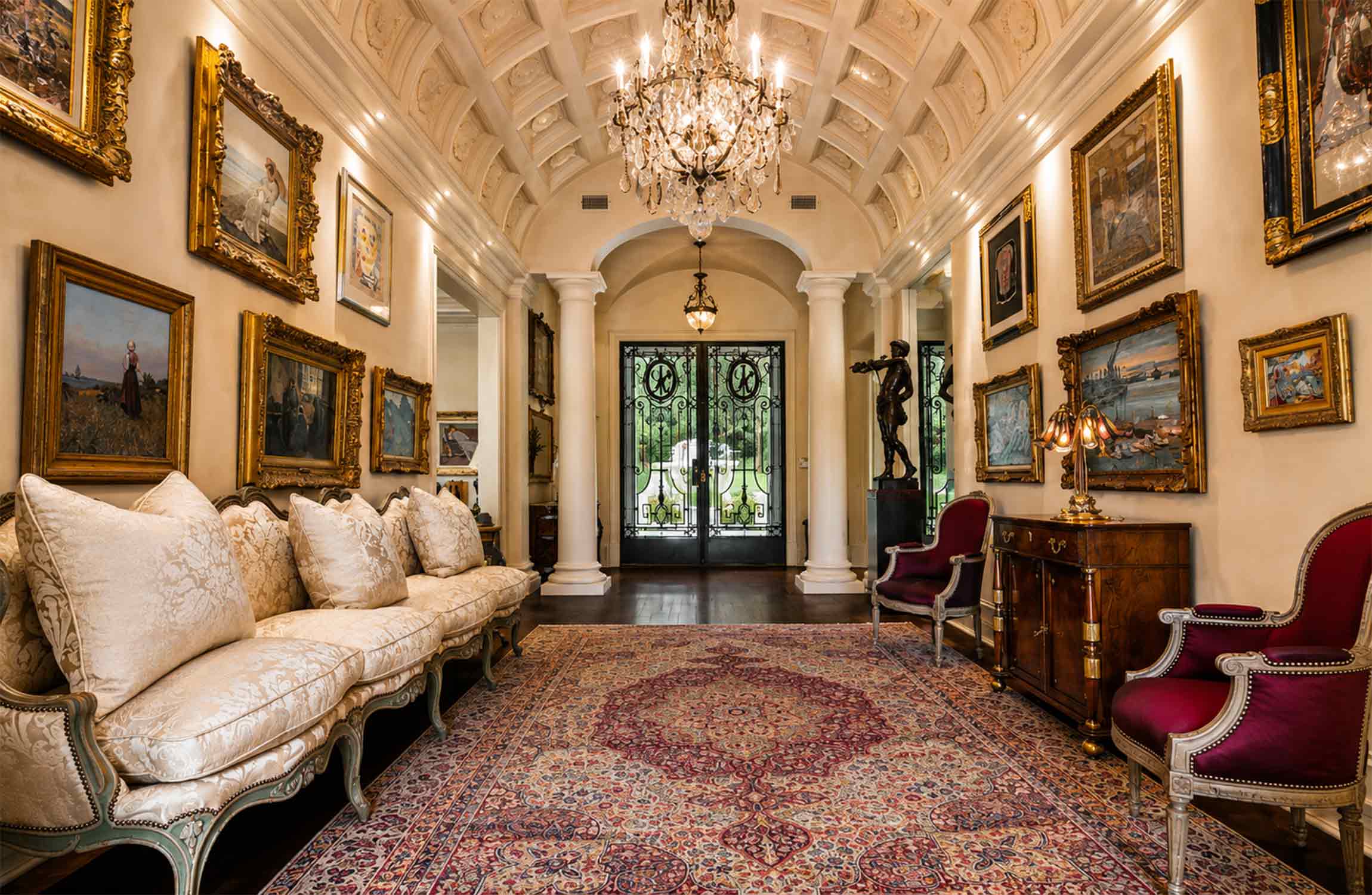 Grand entrance gallery at Chestnut Hall, featuring Parisian wrought-iron doors, crystal chandeliers, European artwork and elegant classical interiors.