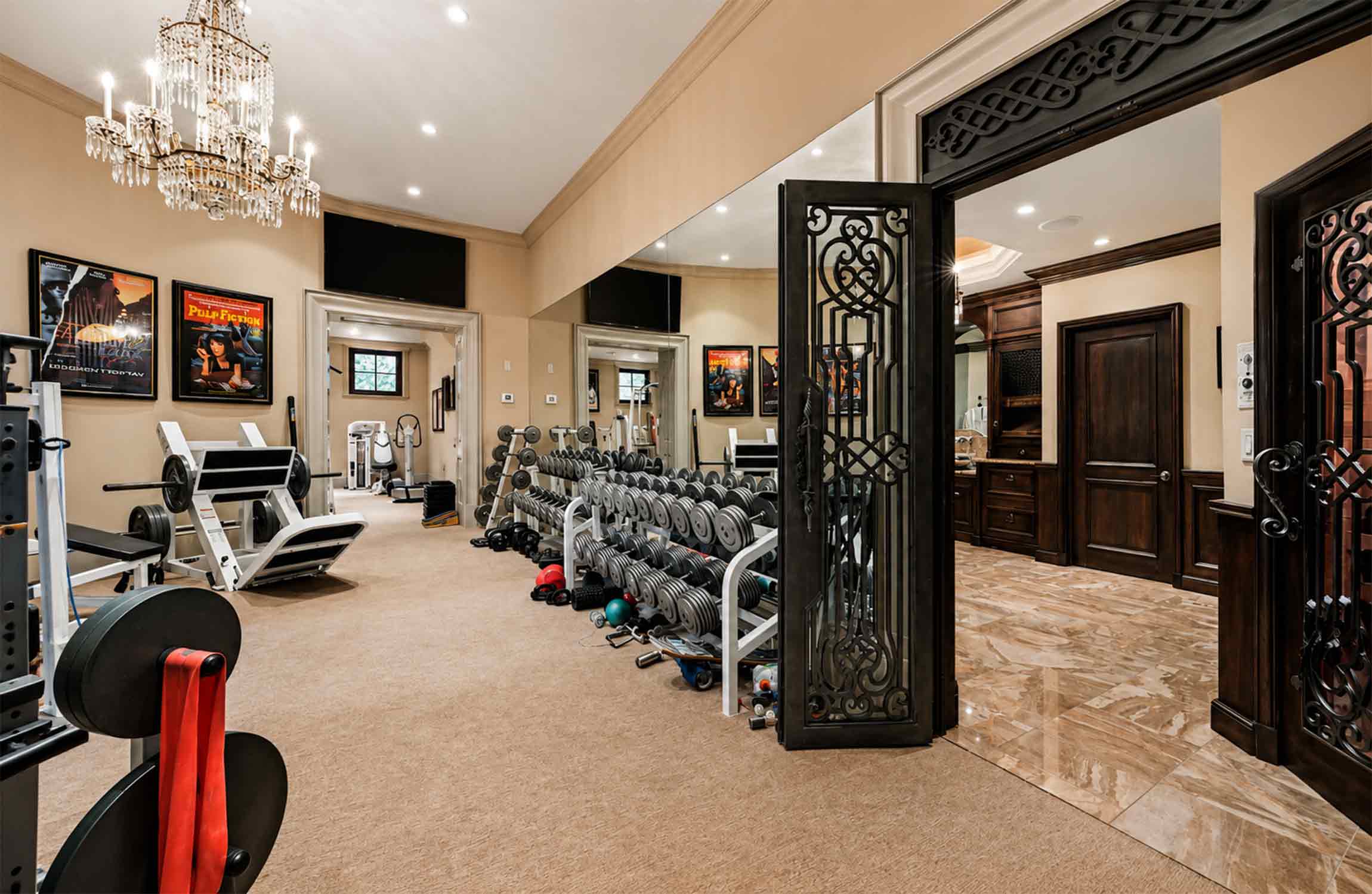 Private fitness centre at Chestnut Hall, featuring professional gym equipment, elegant interiors, crystal chandeliers and bespoke wrought-iron doors.