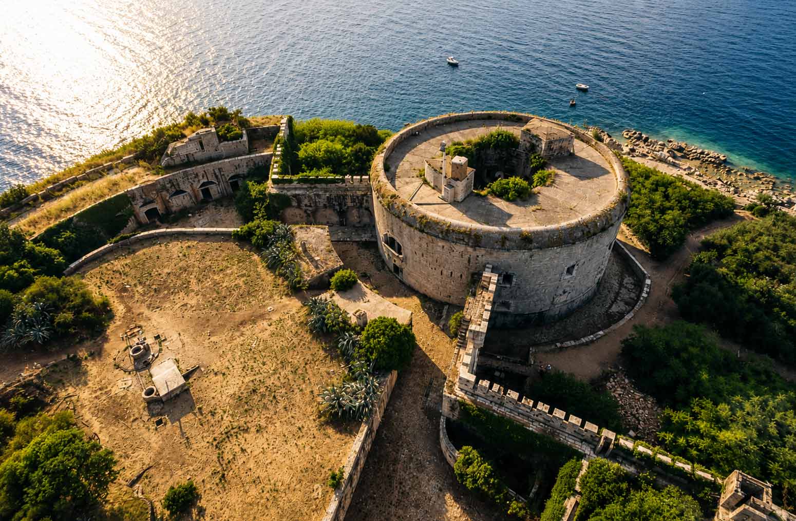Aerial view of the historic Mamula Island fortress in Montenegro before its restoration into a luxury hotel, surrounded by the Adriatic Sea.