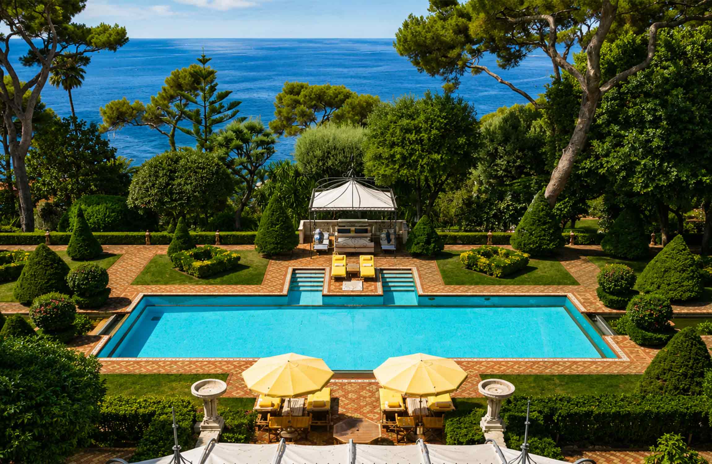 Swimming pool and Mediterranean gardens at Villa Cypris in Roquebrune-Cap-Martin, overlooking the Mediterranean Sea near Monaco.