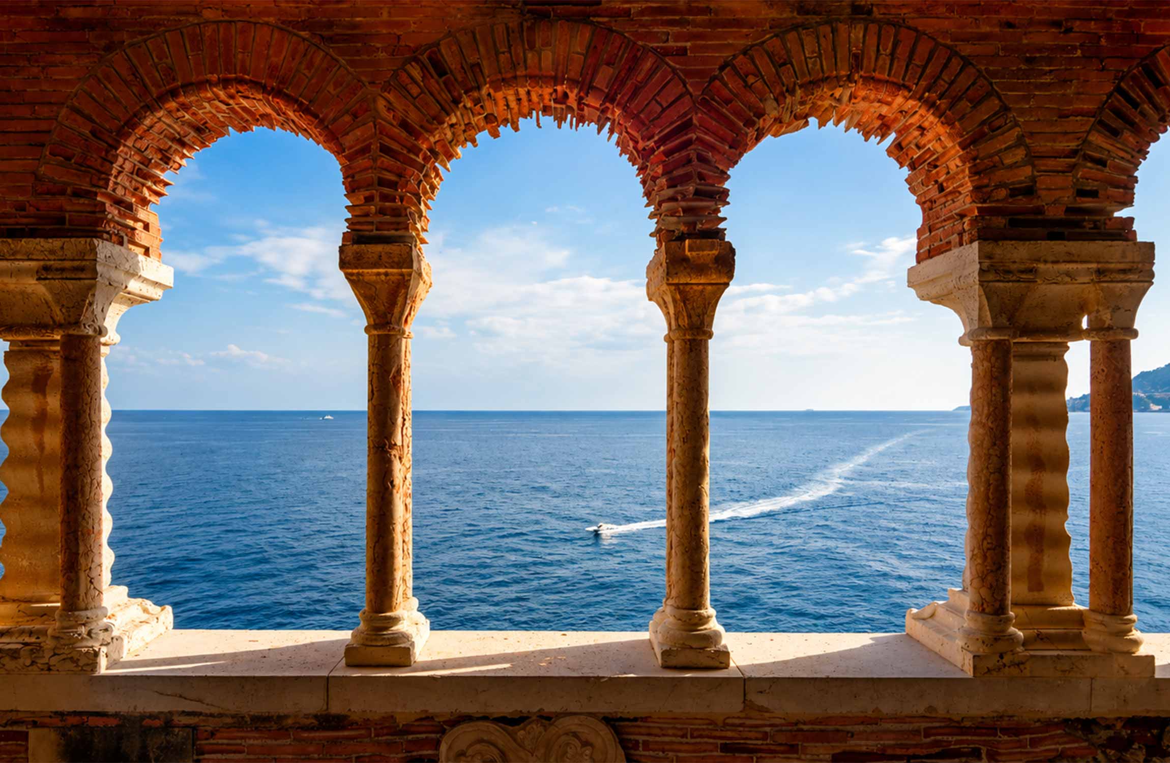 Mediterranean Sea view through the historic brick and stone arches of Villa Cypris in Roquebrune-Cap-Martin on the French Riviera.