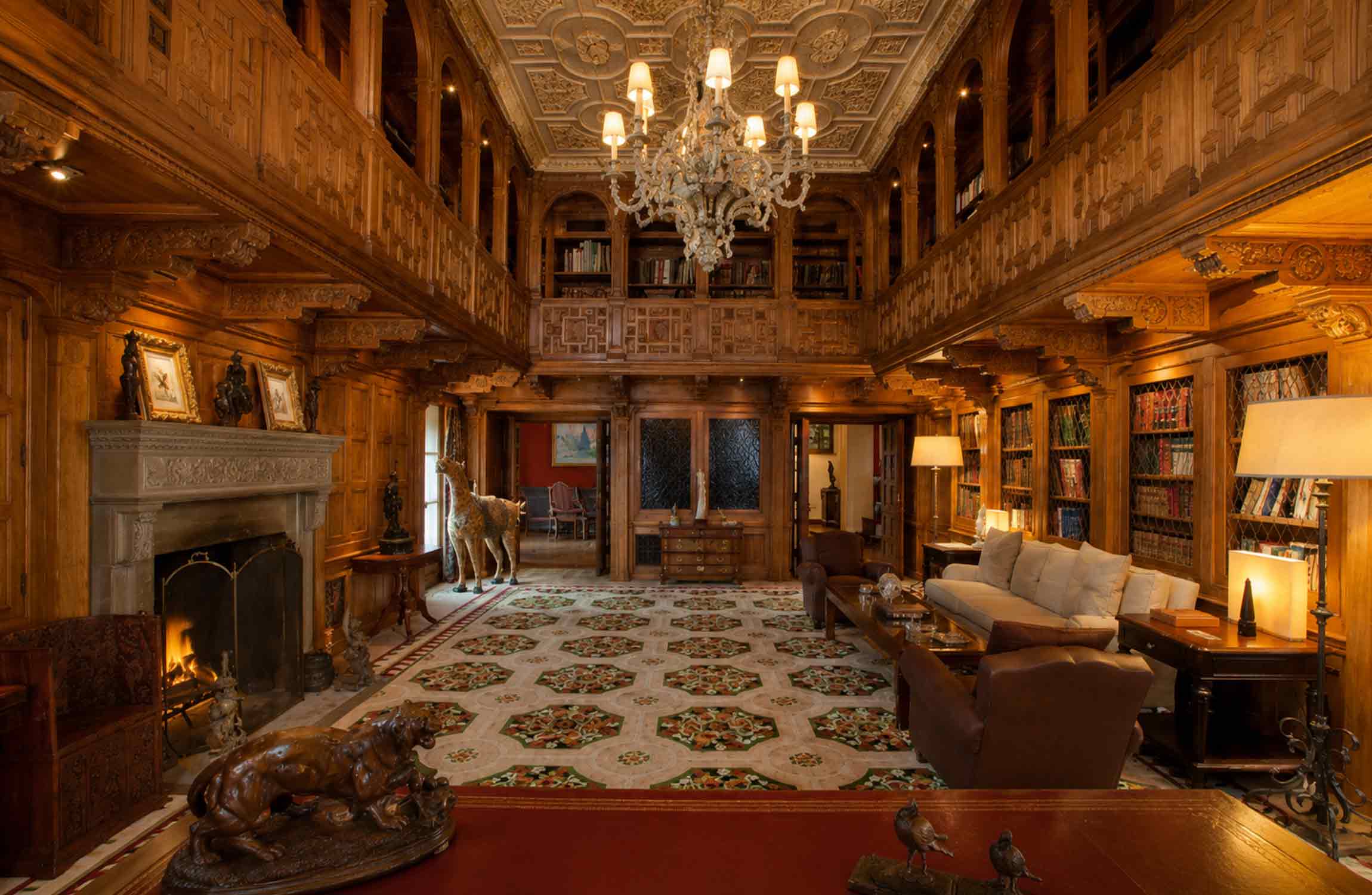 Luxury interior of Villa Leopolda in Villefranche-sur-Mer with an ornate private library, fireplace and grand wood-panelled architecture