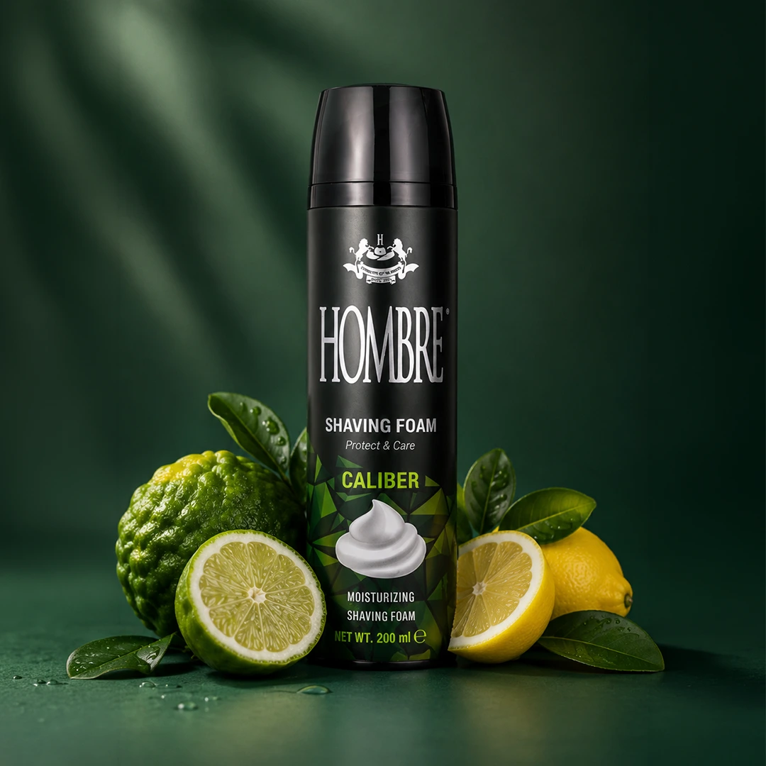 HOMBRE® Caliber shaving foam with bergamot, lime and citrus fragrance notes — ingredient flat lay on green background