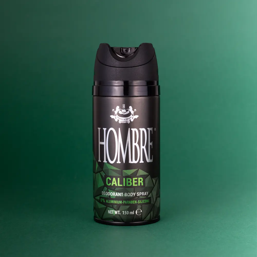 HOMBRE® Caliber deodorant body spray for men on dark green background — aromatic green marine scent