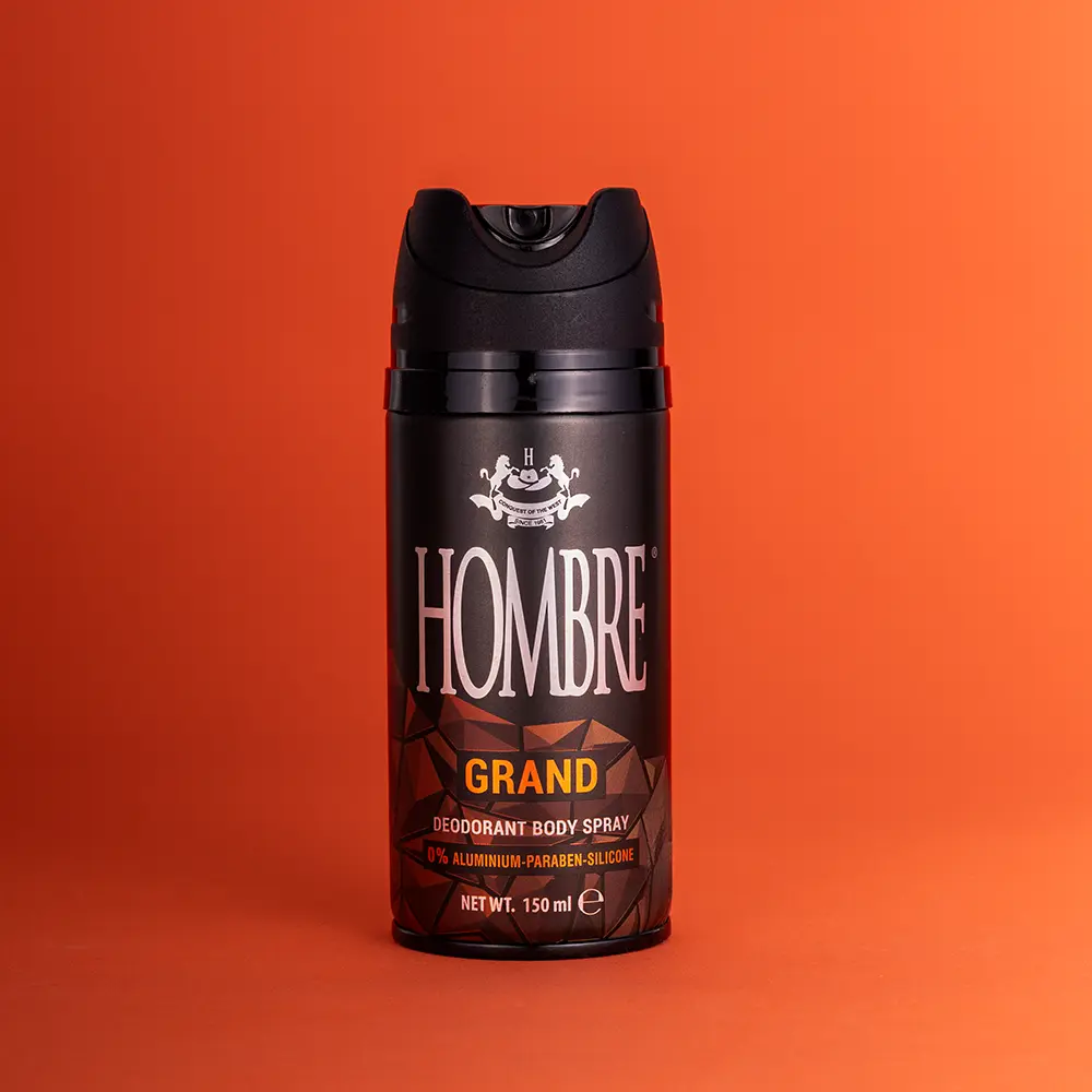 HOMBRE® Grand deodorant body spray for men on orange background — warm citrus and spice scent