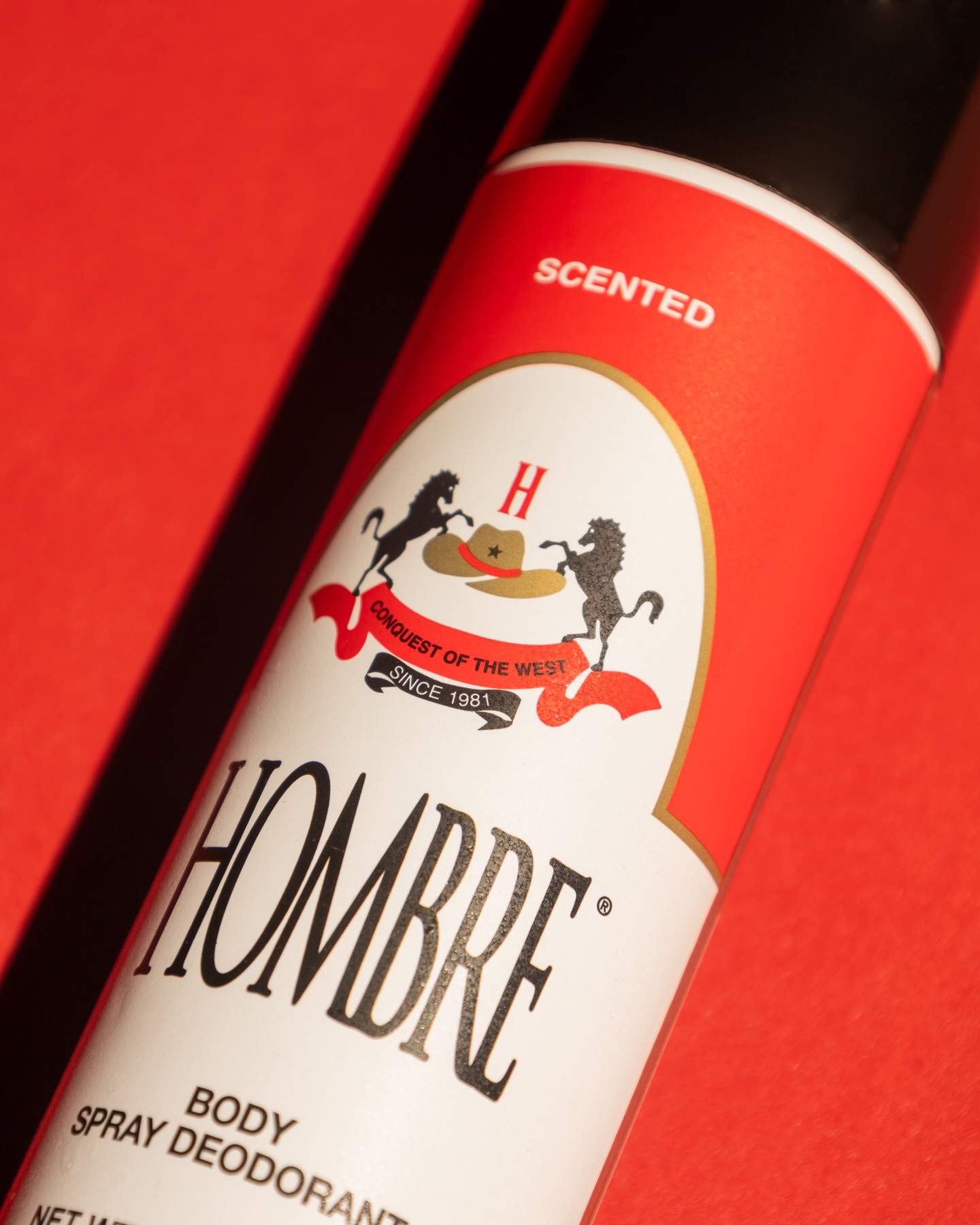 HOMBRE® Red deodorant spray can close-up showing classic logo and body spray label