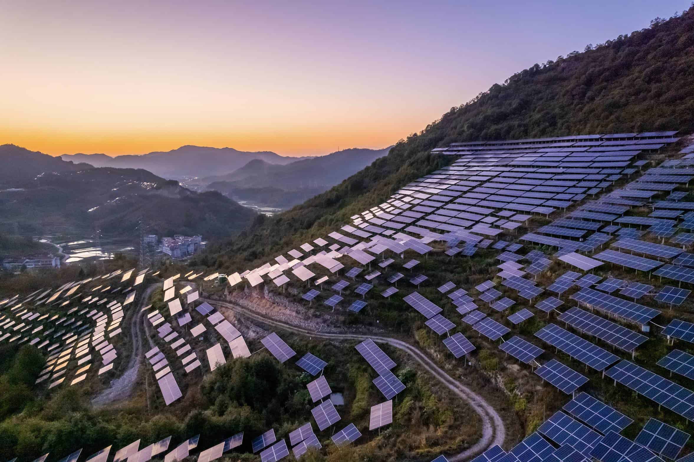 Commercial solar panels installed with mountains in the background