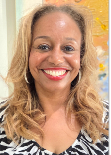 Smiling woman with long wavy blonde hair wearing hoop earrings and a zebra-patterned top in front of a colorful background.
