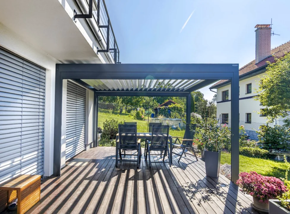 Malá bioklimatická pergola ARTOSI u rodinného domu, pohled za soumraku. Součást aktuální nabídky pergol.