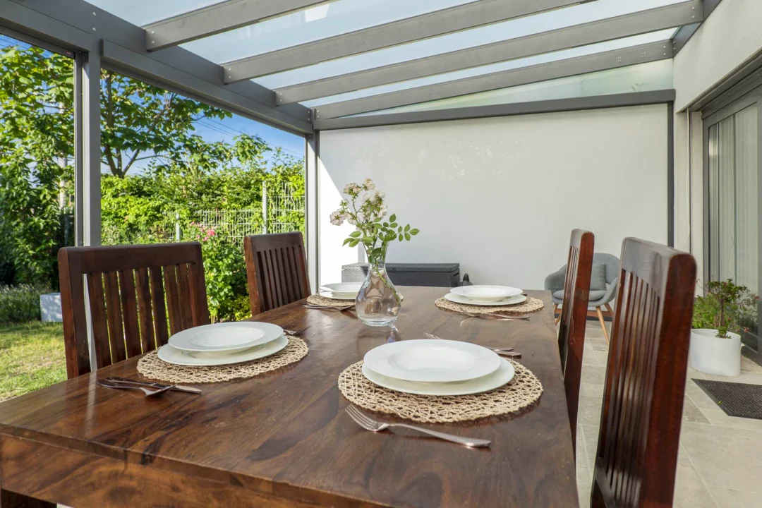 Skleněná pergola GLASETTI se stínicí technikou, pohled ze zahrady. Součást aktuální nabídky pergol.