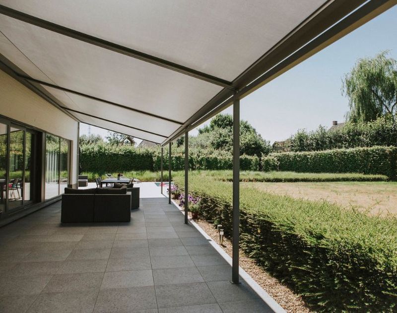 Pergola se stahovací textilní střechou na terase. Realizace na zahradě rodinného domu.