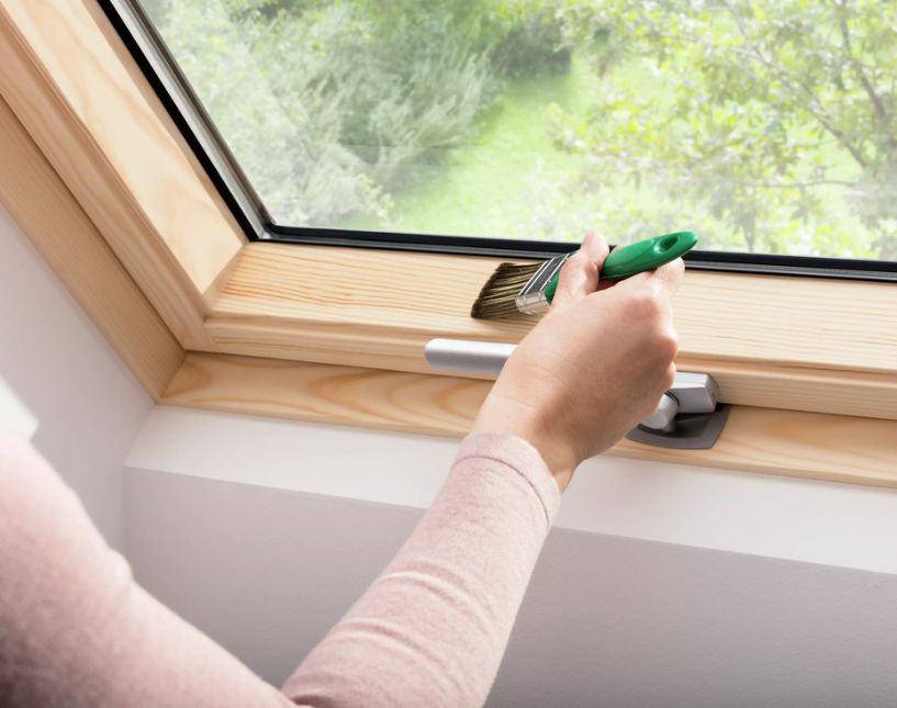 Technik provádí servisní kontrolu a údržbu střešního okna VELUX v podkroví domu.