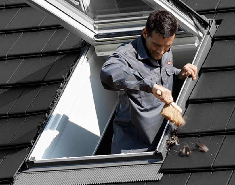 Detail pryžového těsnění na rámu střešního okna VELUX v podkrovní obytné místnosti.