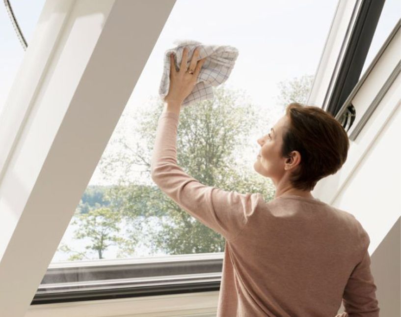 Mytí skla střešního okna VELUX hadrem pomocí prodloužené teleskopické tyče s nástavcem.