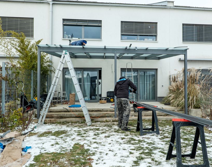 Stavba skleněné pergoly na zahradě s dodržením odstupu od sousedního pozemku domu.
