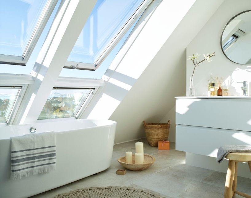 Bílé bezúdržbové střešní okno VELUX v koupelně, odolné vůči vlhkosti, prachu a plísni.