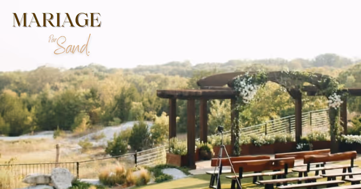 Cérémonie de mariage extérieur avec arche en bois décorée de verdure, bancs alignés et vue sur la nature.