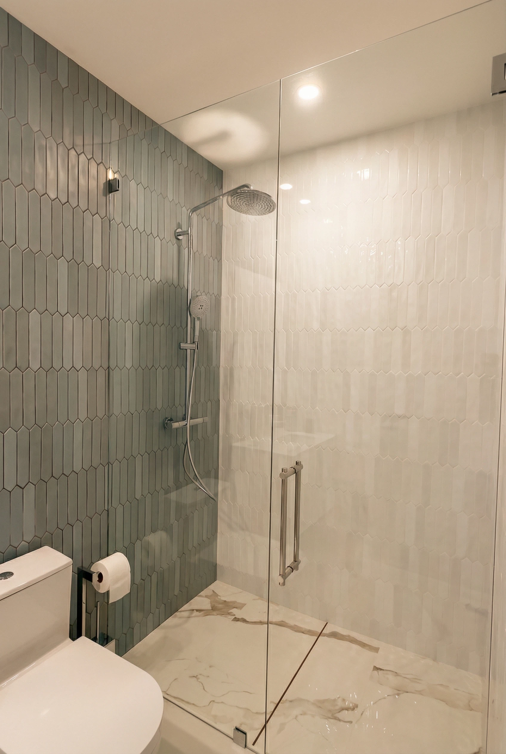 Hexagon tile glass shower installation with rainfall showerhead in Miami bathroom