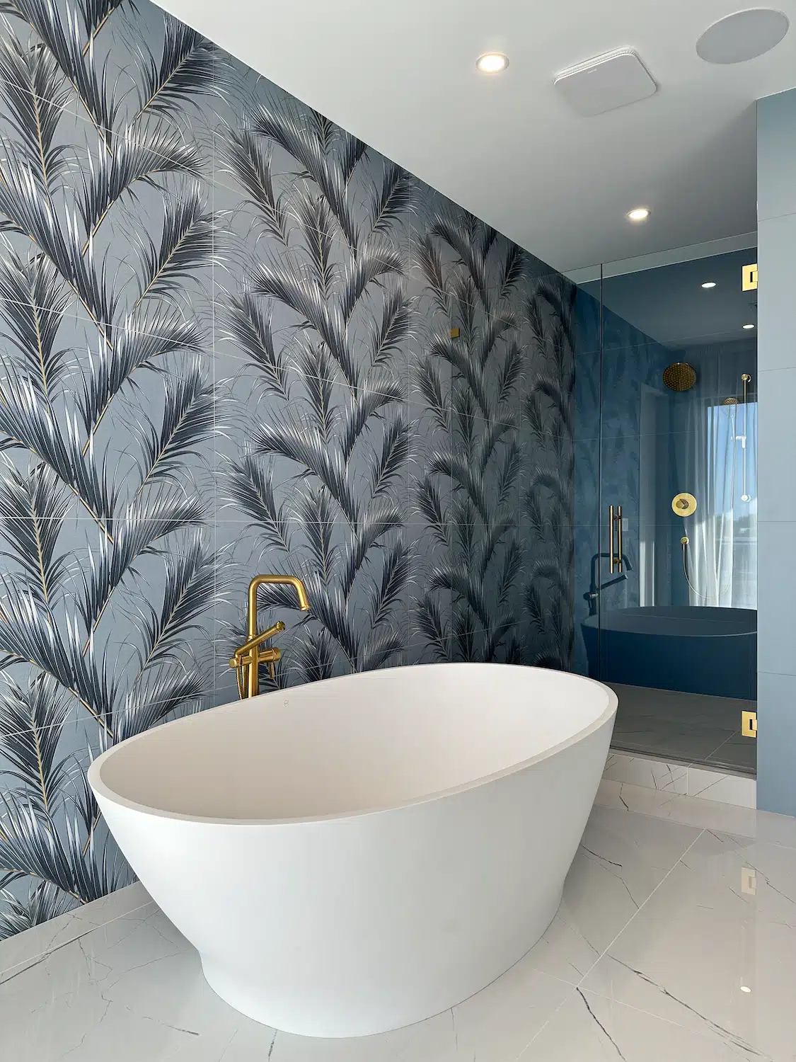 Customer review featuring a custom luxury bathroom renovation by ArtivaTile in Miami with blue porcelain tile, gold fixtures, freestanding tub, and frameless glass shower.
