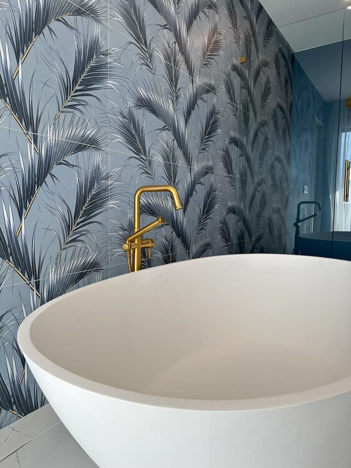 Luxury freestanding bathtub with decorative feature wall and premium tile installation in a Miami bathroom remodel.